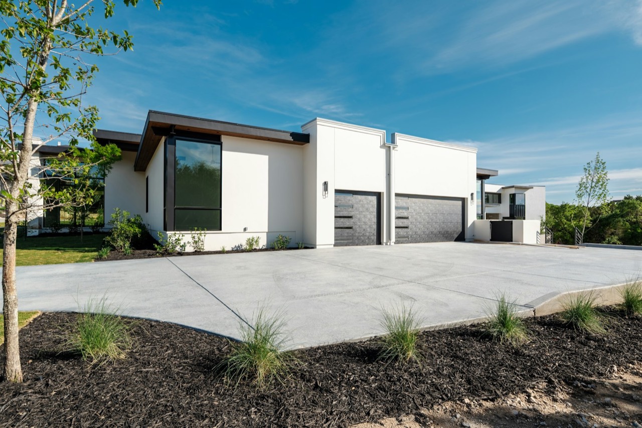 Modern home with attached garage and a wide concrete driveway apron